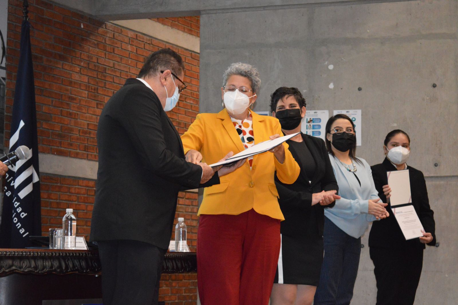 El señor Emmanuel González Alvarado, hace entrega del certificado de acreditación a la señora Yorleny Guevara Cruz, directora de carrera de AGRH Sede San Carlos, para ser entregada a la señora Roxana Venegas, directora de la carrera de la Sede Central y ella hace entrega las estudiantes de la carrera.